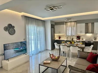 a living room and kitchen with a couch and a table at Flev's Luxury House with pool in Kremasti
