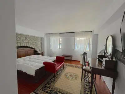 a bedroom with a bed and a desk and a piano at Anamar Symi Residences in Symi