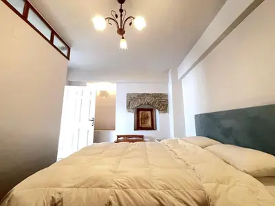 a bedroom with a large bed and a chandelier at Anamar Symi Residences in Symi