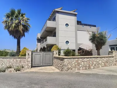 a building with a gate in front of a stone wall at Stamatina's Luxury Penthouse in Pastida Rhodes in Pastida