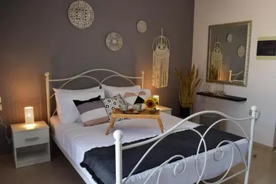 a bedroom with a white bed and a table at Stamatina's Luxury Penthouse in Pastida Rhodes in Pastida
