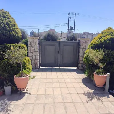 a gate in a garden with two potted plants at Stamatina's Luxury Penthouse in Pastida Rhodes in Pastida