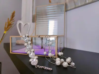 a table with a glass box with a necklace and pearl earrings at Stamatina's Luxury Penthouse in Pastida Rhodes in Pastida