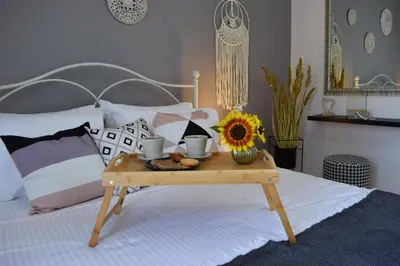 a bed with a wooden tray with a sunflower on it at Stamatina's Luxury Penthouse in Pastida Rhodes in Pastida