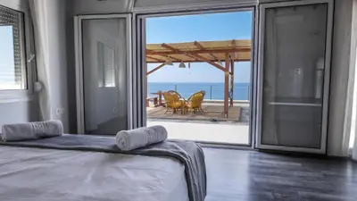 a bedroom with a bed and a view of the ocean at Blue Heaven Kerami in Archangelos