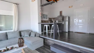 a living room with a couch and a kitchen at Blue Heaven Kerami in Archangelos