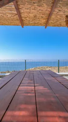 a wooden table with the ocean in the background at Blue Heaven Kerami in Archangelos