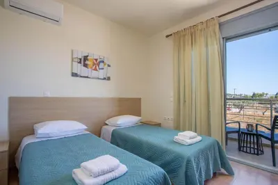 two beds in a room with a balcony at Captain Chris Villa in Afantou