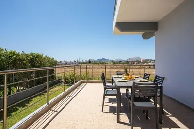 a patio with a table and chairs on a balcony at Captain Chris Villa in Afantou