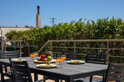 a wooden table with glasses of orange juice and fruit on it at Captain Chris Villa in Afantou