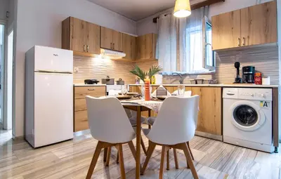 a kitchen with a table and white appliances at Anali Apartment in Ixia