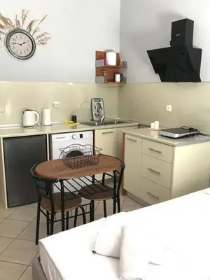 a kitchen with a small table and a counter top at Haplotēs Rhodes Studio in Koskinou