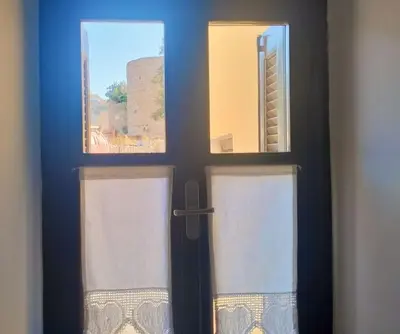 a door with two windows in a room at The Mill House George in Symi