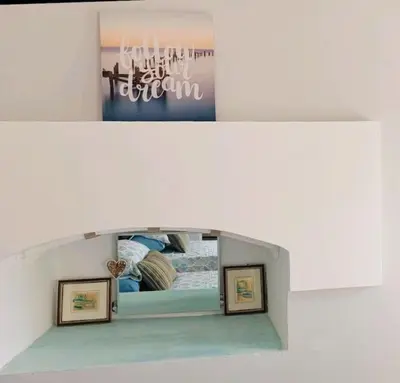 two pictures of a room with a bed and a mirror at The Mill House George in Symi