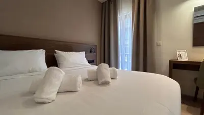 a bedroom with a white bed with towels on it at Elite Centre in Rhodes Town