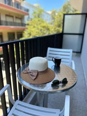 a hat and sunglasses sitting on a table on a balcony at Elite Centre in Rhodes Town