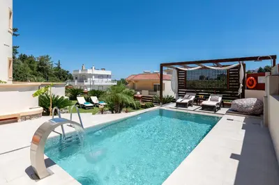 a swimming pool on top of a building at Amarilia House in Koskinou