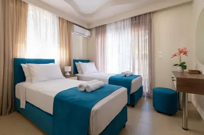 a hotel room with two beds and a desk at Amarilia House in Koskinou