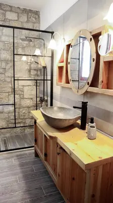 a bathroom with a stone sink and a mirror at Tropical Garden Faliraki Rhodes in Faliraki