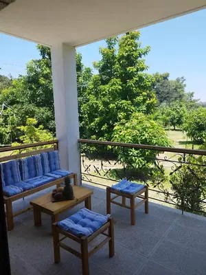 a balcony with two couches and a table and chairs at Tropical Garden Faliraki Rhodes in Faliraki