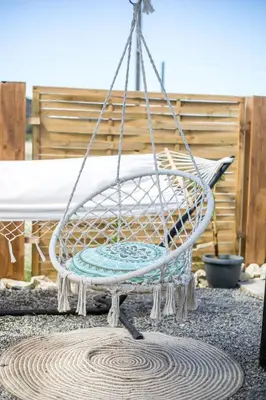 a swinging chair in a patio with at Marco Beach Tiny House in Faliraki