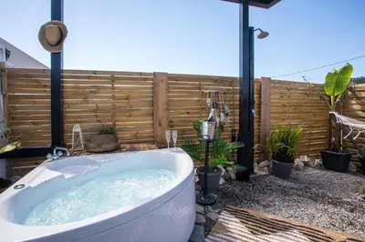 a bath tub in a backyard with a fence at Marco Beach Tiny House in Faliraki