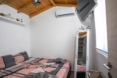 a bedroom with a bed and a mirror at Marco Beach Tiny House in Faliraki