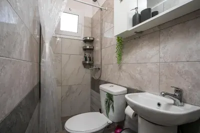 a bathroom with a toilet and a sink at Marco Beach Tiny House in Faliraki