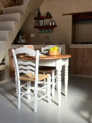 a kitchen with a table with chairs and a sink at Katrani studios in Symi