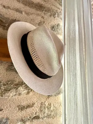a white hat is hanging on a wall at Katrani studios in Symi