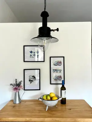 aendant light hanging over a table with a bowl of fruit at Katrani studios in Symi