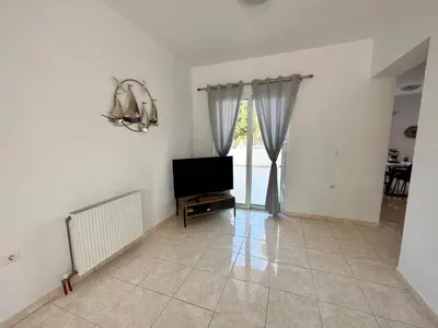a living room with a television and a window at Treditto House - Ground Floor residence C1 in Koskinou