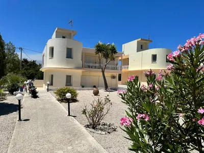a building with pink flowers in front of it at Treditto House - Ground Floor residence C1 in Koskinou