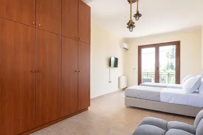 a bedroom with a bed and wooden cabinets at Sun Dream Villa in Ialyssos