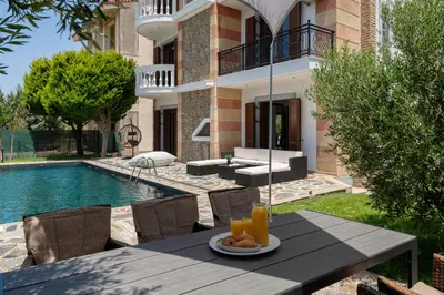 a table with a plate of food on it in front of a house at Sun Dream Villa in Ialyssos