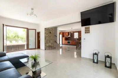 a living room with a couch and a glass table at Sun Dream Villa in Ialyssos