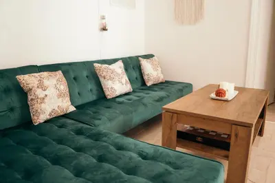 a green couch in a living room with a wooden table at Villager's Art Apartment in Paradeísion