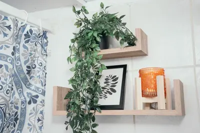 a green ivy wreath on a wall with wooden shelves at Villager's Art Apartment in Paradeísion
