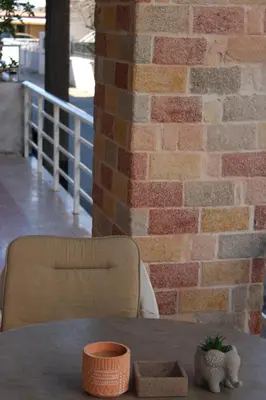 a table and a chair in front of a brick wall at Villager's Art Apartment in Paradeísion