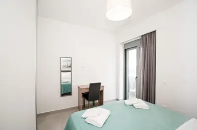 a bedroom with a green bed and a desk at Anesis Town Apartments in Rhodes Town