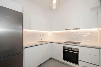 a white kitchen with white cabinets and a sink at Anesis Town Apartments in Rhodes Town