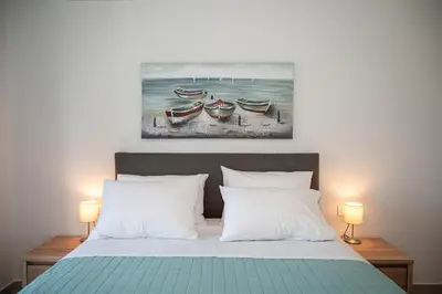 a bedroom with a bed with two boats on the beach at Anesis Town Apartments in Rhodes Town