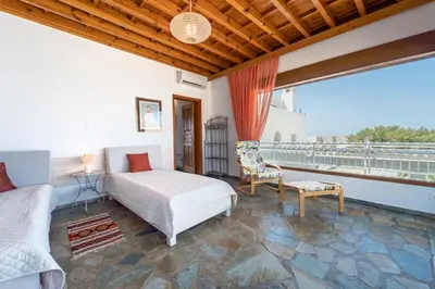 a bedroom with a bed and a balcony at Arte Pefki Beachfront Suites in Pefki Rhodes