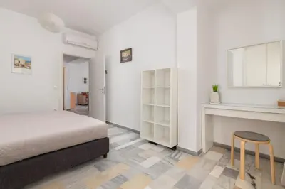 a bedroom with a bed and a table and a stool at Arte Pefki Beachfront Suites in Pefki Rhodes