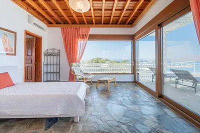 a bedroom with a bed and a balcony at Arte Pefki Beachfront Suites in Pefki Rhodes
