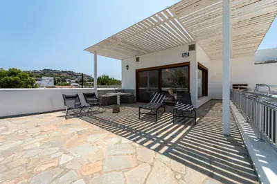 a patio with chairs and a table on a roof at Arte Pefki Beachfront Suites in Pefki Rhodes