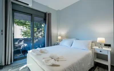 a bedroom with a bed and a large window at Eramel Cozy Apartment with Sea View in Rhodes Town