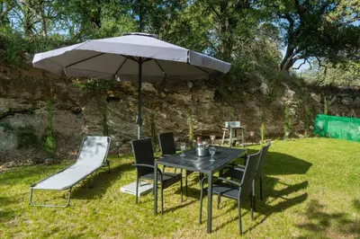 a table and chairs under an umbrella in the grass at Eramel Cozy Apartment with Sea View in Rhodes Town