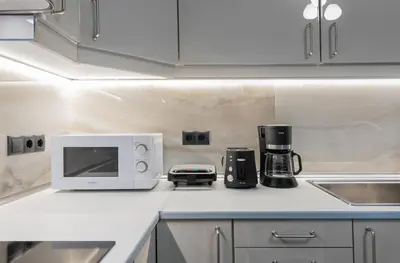 a kitchen counter with a white microwave oven and appliances at Eramel Cozy Apartment with Sea View in Rhodes Town