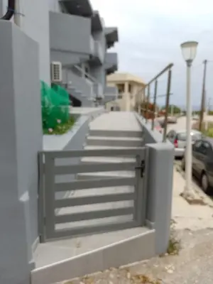 a fence with a gate in front of a house at Eramel Cozy Apartment with Sea View in Rhodes Town